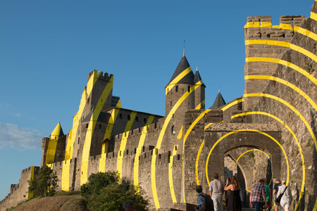 the west entrance of carcassonne citadel on a sunny day with some tourists.のeditorial素材