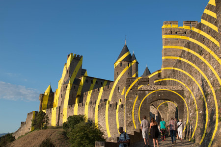the west entrance of carcassonne citadel on a sunny day with some tourists.のeditorial素材