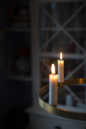 Winter, christmas or hygge background with candles glowing on a golden advent chandelier. Vertical shot with copy space.の写真素材