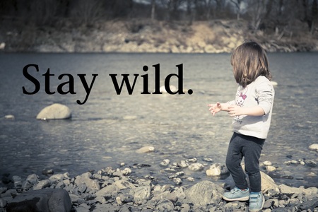 Toddler baby girl playing on the rocky river beach. Rivergaro, Val Trebbia, Italy.の写真素材
