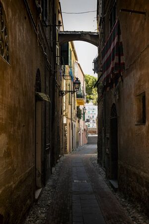 Picturesque narrow alley with a cloth hanging dry, in Albenga, Liguria, italy.の写真素材