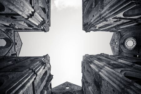 Bottom up view of San Galgano abbey with the cross shape in the sky. Tuscany, Italy. Black and white.の写真素材