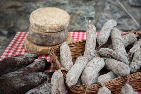 artisan cheese and sausages, typical italian products, exposed on a table at a local farmers market.