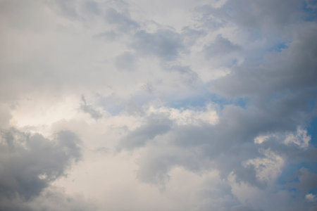 Grey and white stormy clouds framing a portion of blue sky. Heavenly or weather background or...
