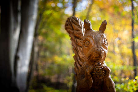 Squirrel carved wooden sculpture by artist Sergio Terni in the "Path of sculptures", in Campo dei Fiori Park, near Varese, Italy. Close up.のeditorial素材