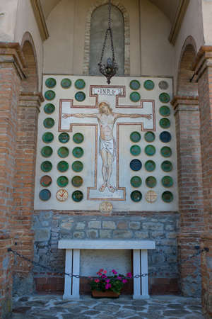 Christian cross outside Santa Maria and San Giorgio church in Fortunago, one of the most charming villages of OltrepÃ² Pavese, Lombardia countryside, Italy.の写真素材