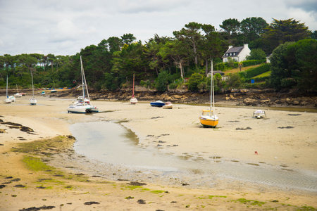 View of Plage de la Minaouet during low tide, with boats grounded ashore. Finistere, Brittany, France.の写真素材