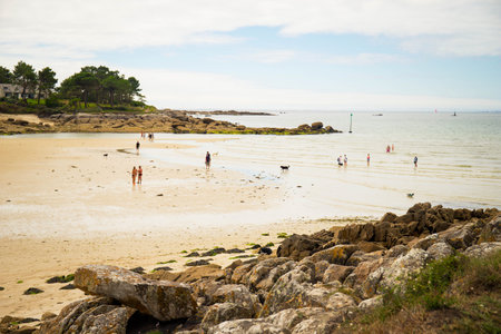 People, not recognisable, enjoying Plage de Minaouet beach during low tide. Finistere, Brittany, France.の写真素材