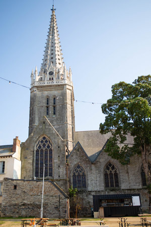 The bell tower of the gothic Notre Dame cathedral in VitrÃ©, Brittany, France. View from the Benedictine garden. Vertical shot, sunny and bright summer day.の写真素材