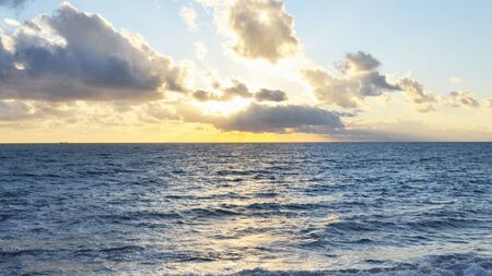 Sunset by the sea with water wavesの写真素材