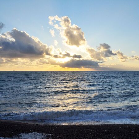 Sunset by the sea with water wavesの写真素材
