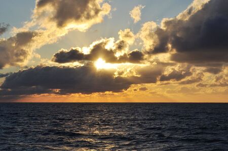 Sunset by the sea with water wavesの写真素材