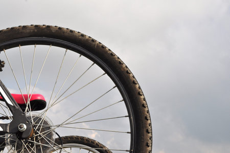 Detail of bicycle wheels outdoor against the blue sky with clouds