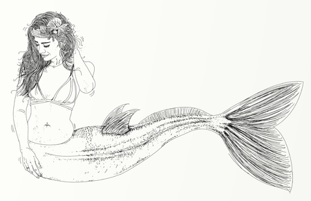 Long-haired mermaid leaning to her side and facing the viewerの写真素材