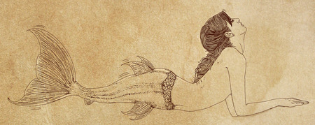 Long-haired mermaid leaning to her side and facing the viewerの写真素材