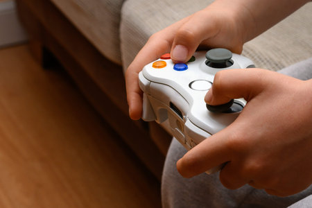 two child's hand holding video game console controller