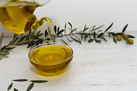 Background with bottle and bottle of extra virgin olive oil decorated with olive branch and olives. Mediterranean diet conceptの写真素材