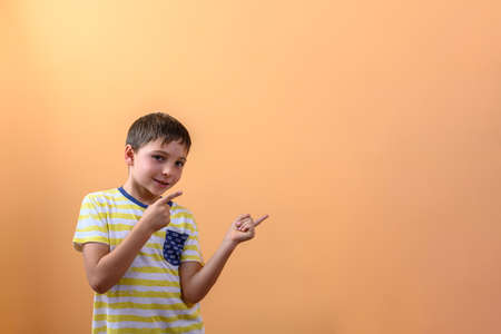 Child smiling, pointing one finger of each hand to the side. Concept of an advertisement to present or show somethingの写真素材