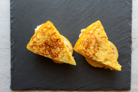 Two skewers of potato omelette, typical of Spanish cuisine as seen from above.
