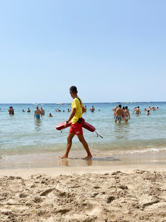 Valencia, Spain, August 18, 2022: Lifeguard strolls along the shore of the beachのeditorial素材