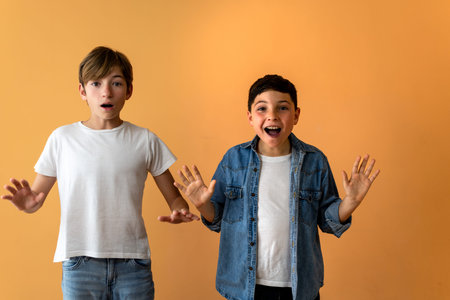 Two children, with raised hands and surprised expressions