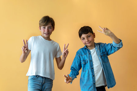 Two smiling children with fingers raised in victory