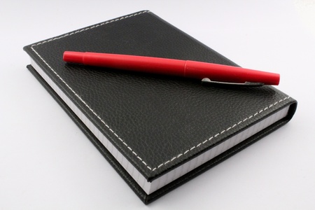 Black notebook with red penの写真素材
