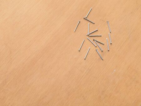 Carpentry material, several new nails on wooden background boardの写真素材