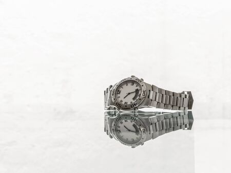 Used wristwatch in brushed steel with reflection on white backgroundの写真素材