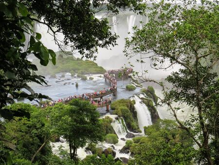 Foz do Iguassu, Parana, Brazil, February 7, 2019, view of the Iguassu Falls in the distance, among the branches of the forest, and tourist boardwalk.のeditorial素材