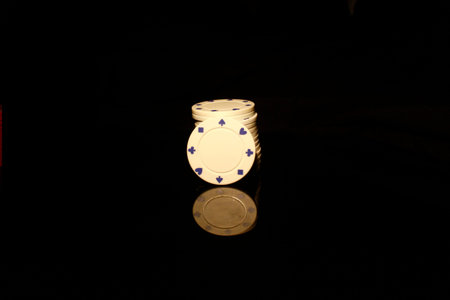 White chips stack with a White chip in front isolated on black with reflection