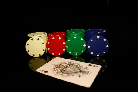White, red, green, blue pocker chips stack with four  chips and an ace card in front isolated on...