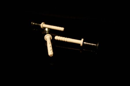 Three wall dowel pin with screw isolated on black with reflectionsの写真素材
