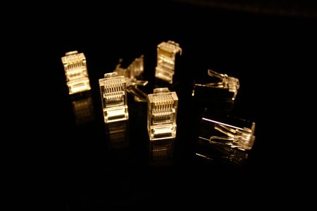 UTP and FTP cable adapters isolated on black with reflectionsの写真素材