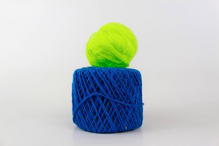 Yellow glow yarn on a top of a blue yarn isolated on white backgroundの写真素材