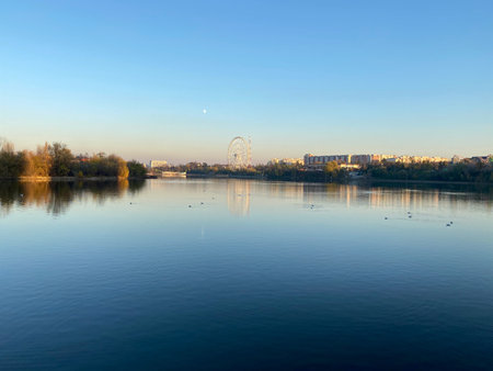 Amusement park, city and moon reflection on a lake