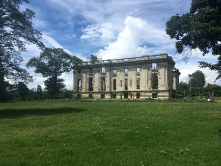 The ruins of Trianon Cantacuzino Palace landscape view with grass and blue sky with white cloudsのeditorial素材