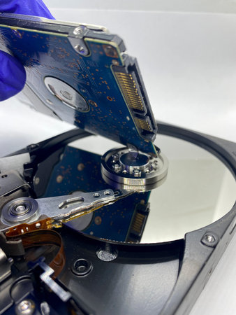 Close-up of small hard disk reflections on silver plate of a hard disk isolated on white