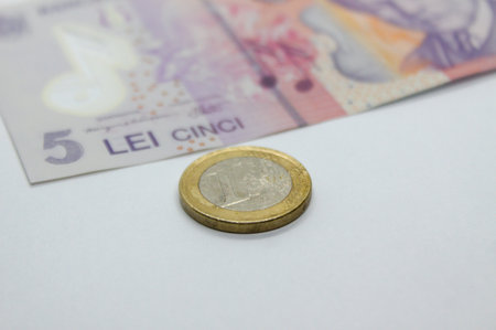 Close-up of one Euro coin near 5 lei banknote. Romanian currency exchange rate for European Union currencyの写真素材