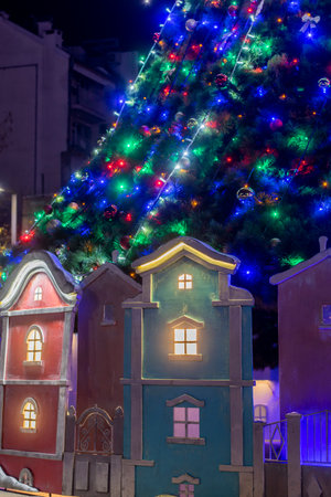 Christmas decorations under a huge Christmas tree in Burgas city centre. Colourful wooden houses used as decorations.の写真素材
