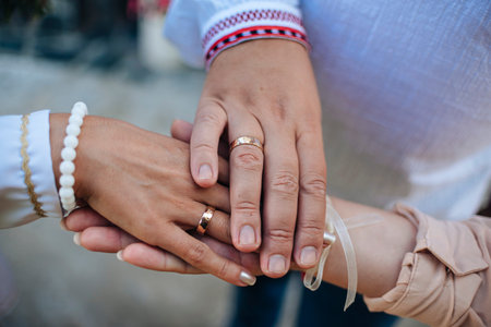 The maid of honor holds the hands of man and woman on their wedding day with wedding rings. New...