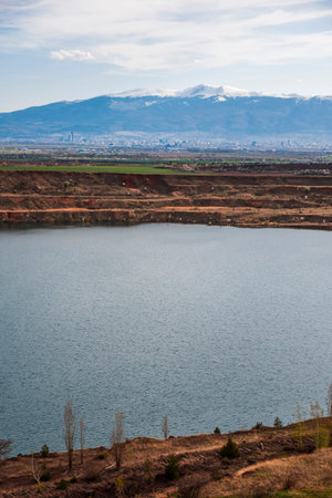 View made over the lake in the former Kremikovtsi mine and views of Sofia and Vitosha Mountain.