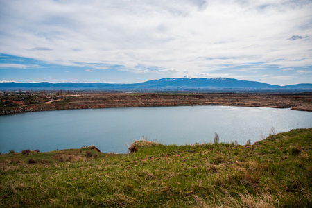 View made over the lake in the former Kremikovtsi mine and views of Sofia and Vitosha Mountain.の写真素材