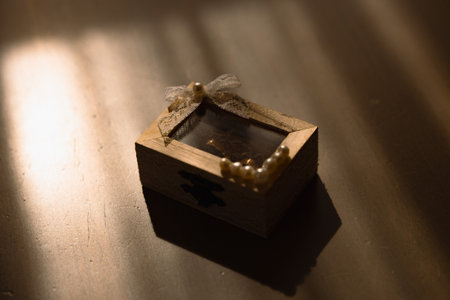 Wooden wedding rings box on a table with golden light coming through the windows. Bride and groom rings in a box. High quality photoの写真素材