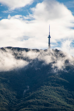 A peak on Vitosha mountain in Bulgaria surrounded by white clouds like mist. Blue sky with clouds. Beautiful landscape.の写真素材