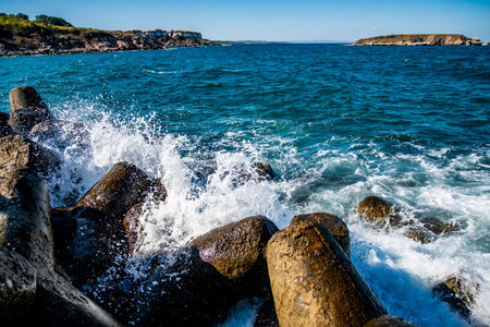 Close up of rocks and waves crashing on them. Water splashing on the rocks
