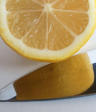 Cuted lemon and blade of knife on white backgroundの写真素材