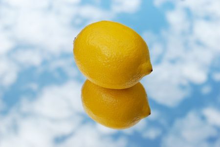 Lemon on mirror with sky の写真素材