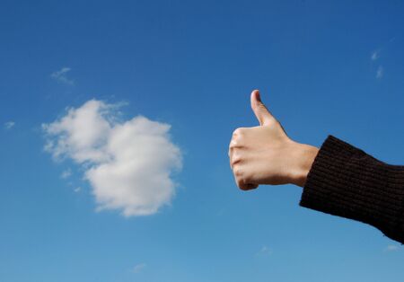 Hand over sky and cloudsの写真素材