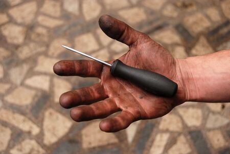 Workers hand with screwdriver の写真素材